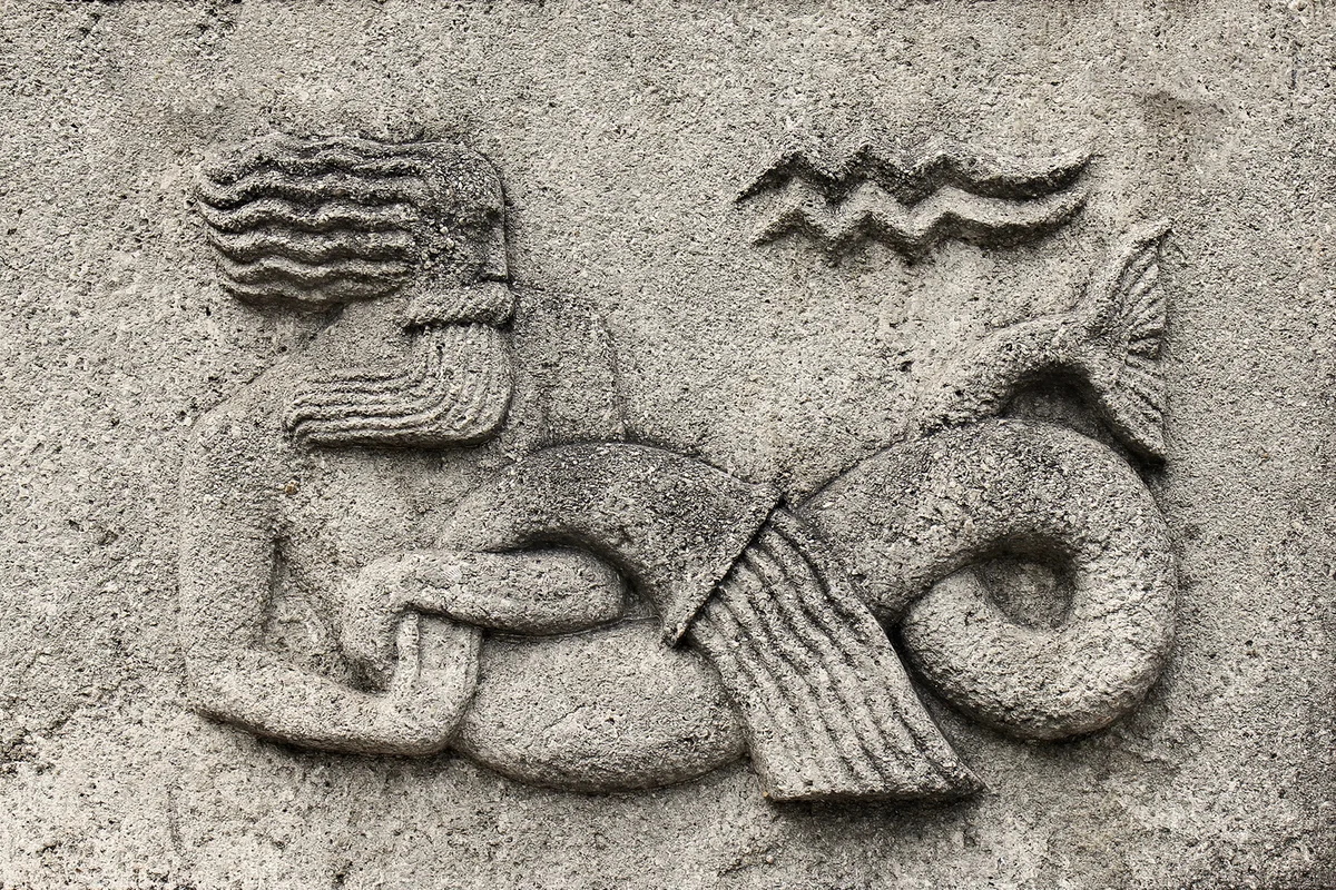 Aquarius or Water-bearer, a stone relief on ancient wall