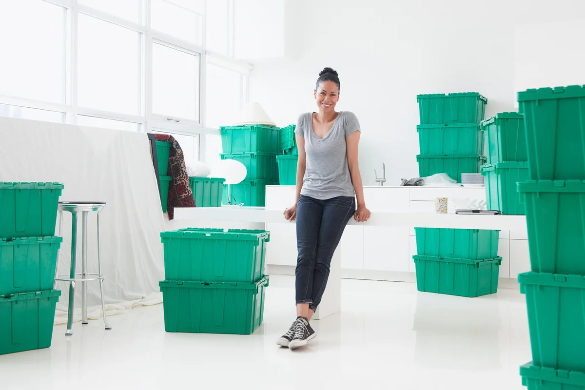 Woman surrounded by green stackable storage bins